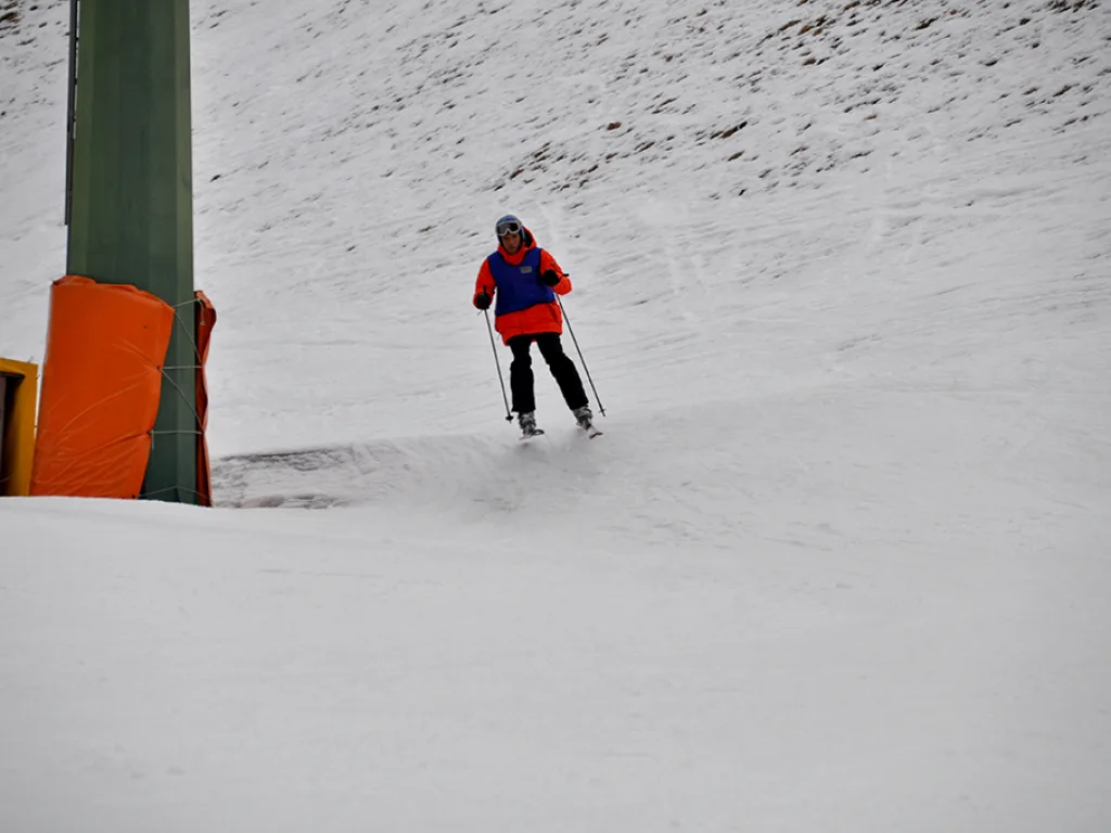 Skifahrer in dunkler Kleidung quert den Hang.
